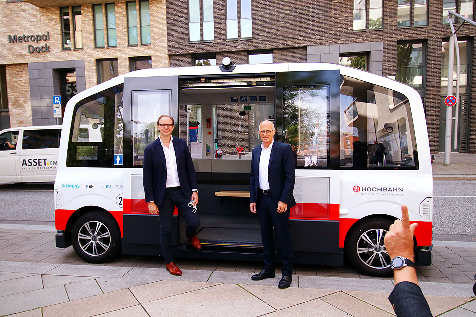 Henrik Falk und Peter Tschentscher vor dem HEAT Bus in der Hafencity