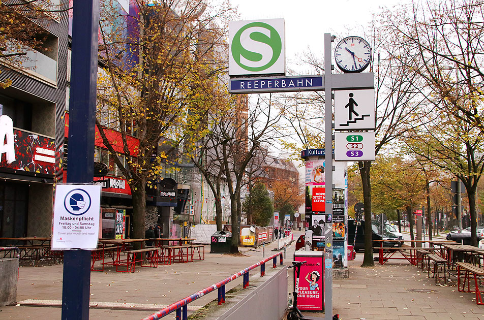 Ein Bahnhofsschild vom Bahnhof Reeperbahn mit Schild zur Masskenpflicht