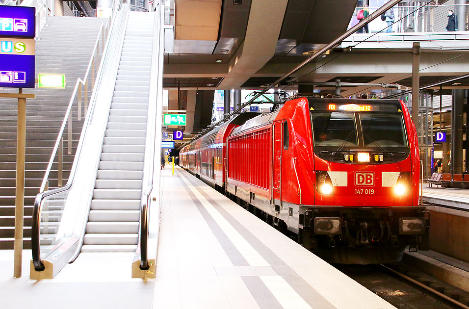 Eine Lok der Baureihe 147 mit einem FEX in Berlin Hbf