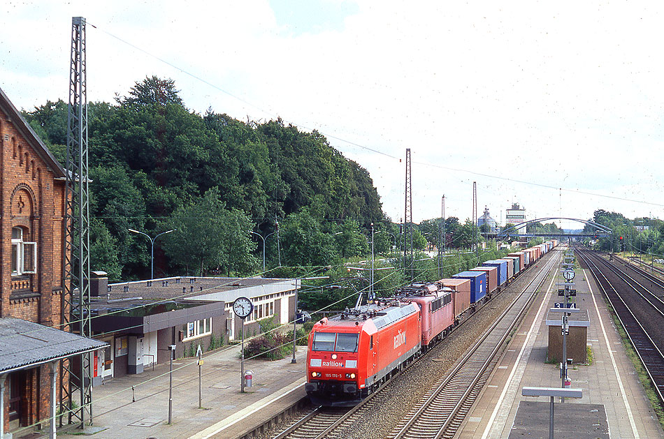 Eine Lok der Baureihe 185 mit einem Containerzug im Bahnhof Tostedt