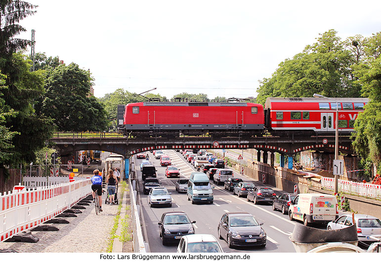 Eine E-Lok der Baureihe 143 auf der Brücke über die Stauffenbergallee in Dresden