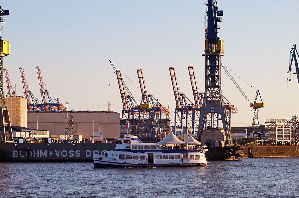 Der Blick von den Landungsbrücken auf das Partyschiff Tonne, Blohm + Voss und Hafenkräne